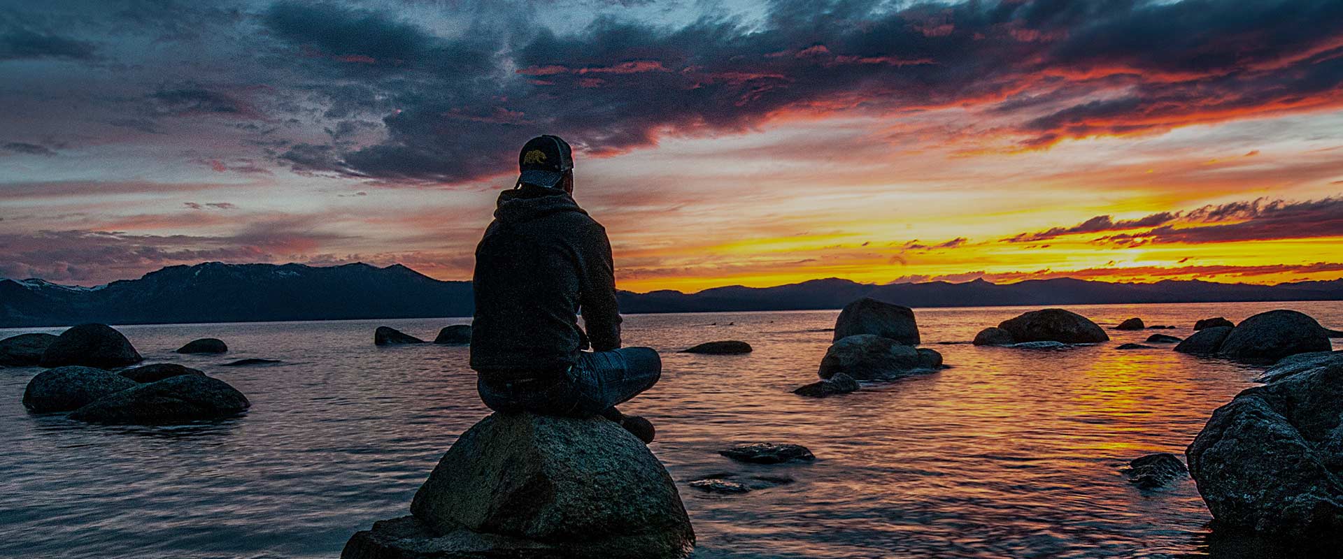 Person sitting on a rock on a river - CRL Australia